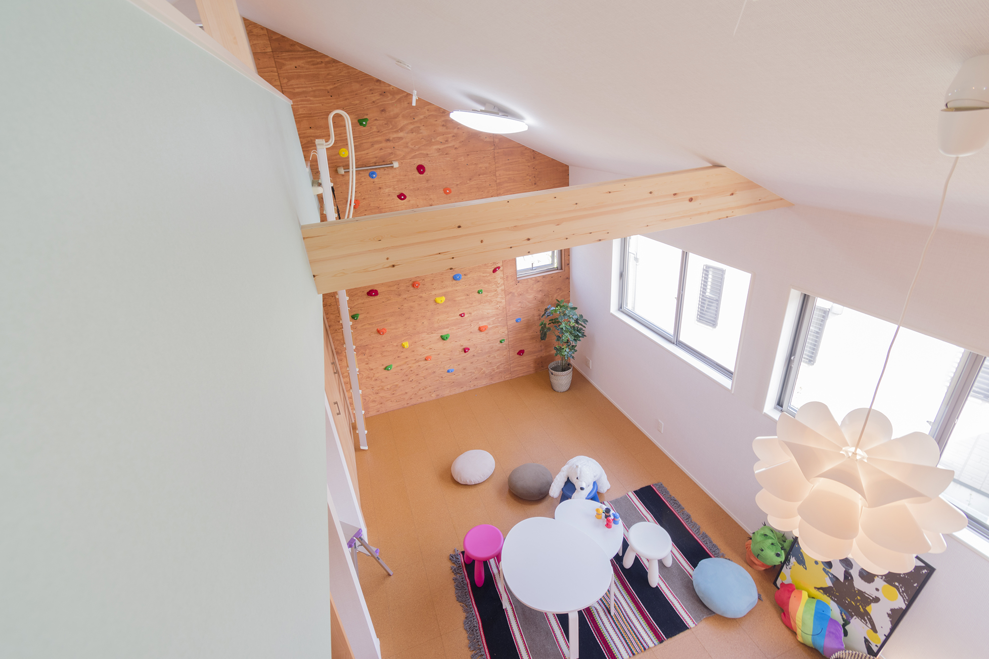 子供部屋は勾配天井にして壁一面にボルダリングウォールを設置