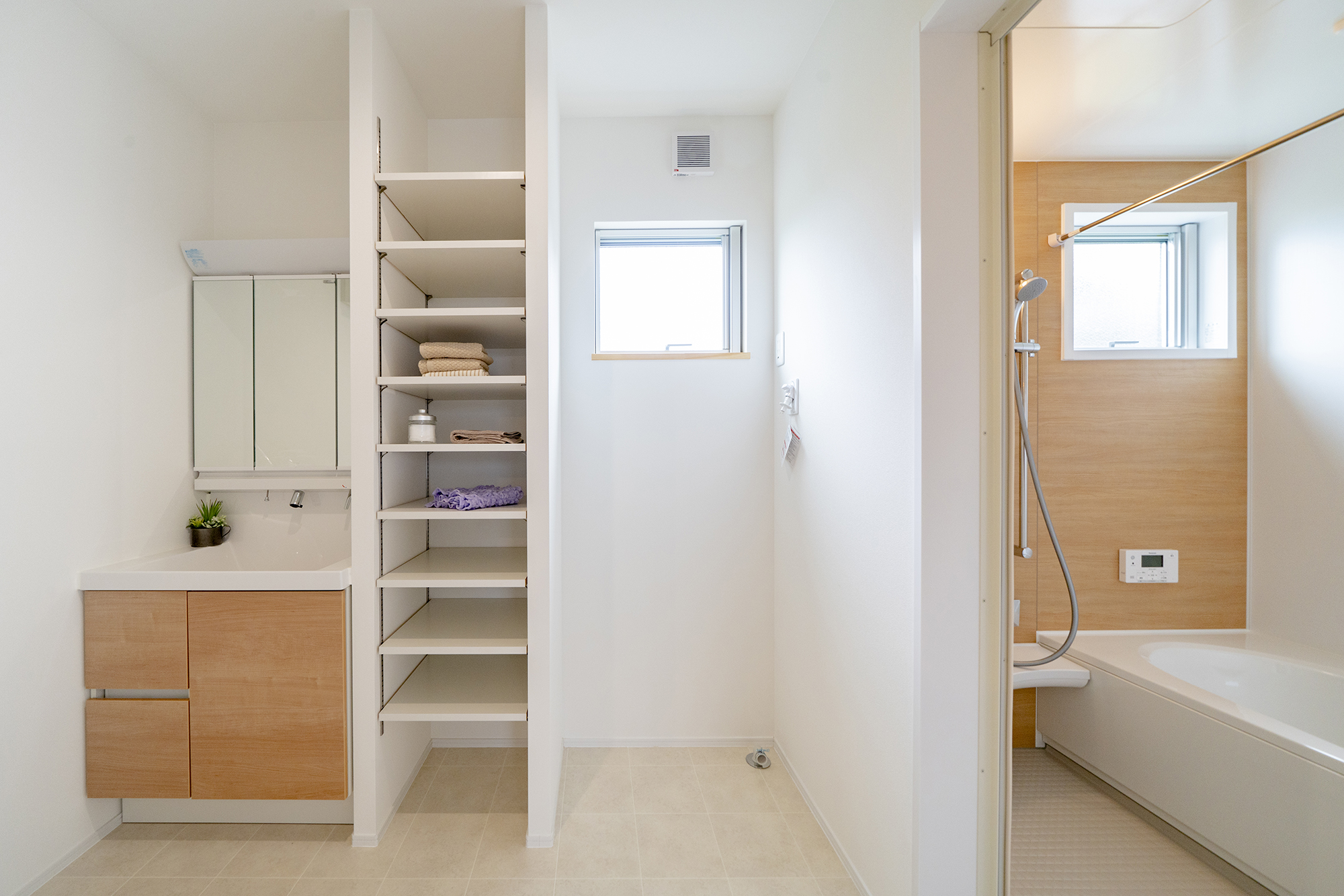 明るく清潔感のある水回りスペース。洗面台の横には、タオルや下着などを置いておける収納棚を設置