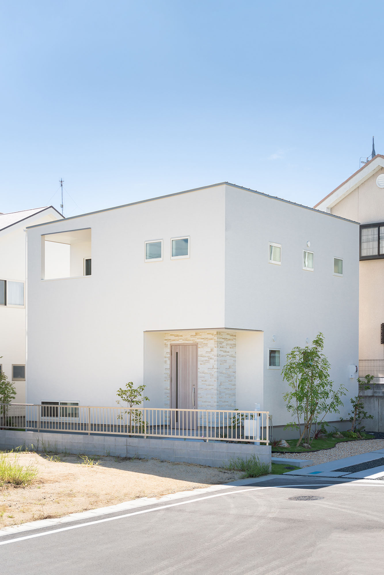 白いキューブ型のシンプルな外観に、植栽の緑が映える。外構は建築設計事務所のWARMS(R)とコラボレーション。植栽が街並みを美しく彩る