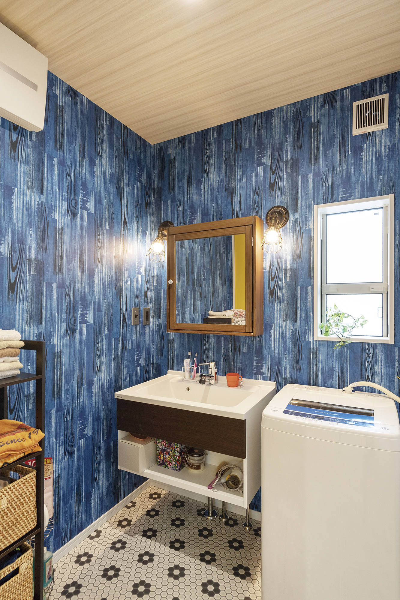 壁紙やフロア材に遊び⼼のある洗⾯室。フロート タイプの洗⾯台が空間を広く⾒せている