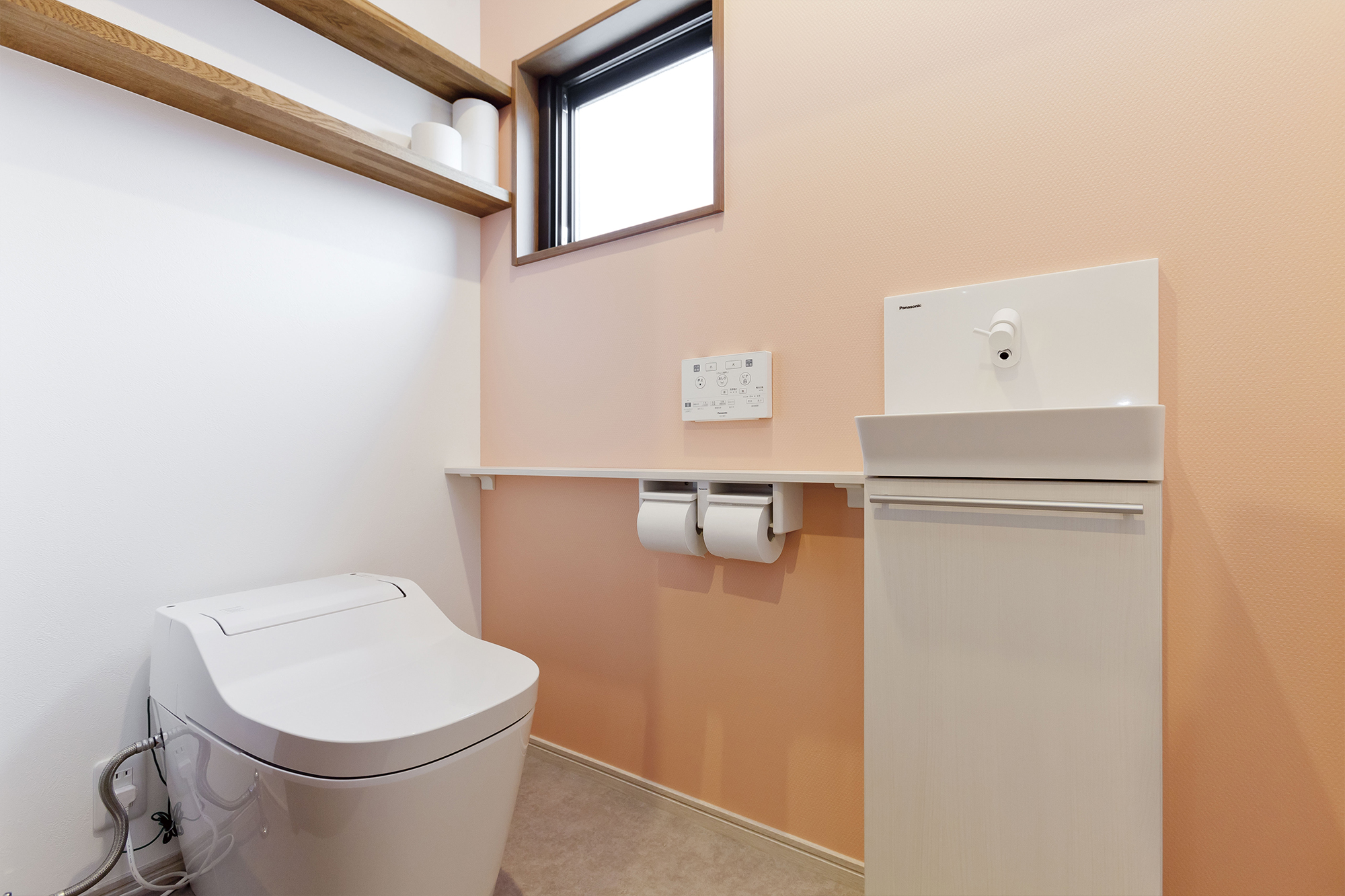 トイレは広めに設計。スペースに余裕があるため掃除もしやすいとか。「建築家の先生に相談して、玄関から直接見えない配置にしてもらいました」。明るいピンクの壁紙で優しい雰囲気に。